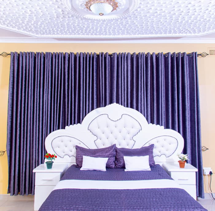 Comfortable en-suite room with a padded headboard, plush pillows and warm lighting.